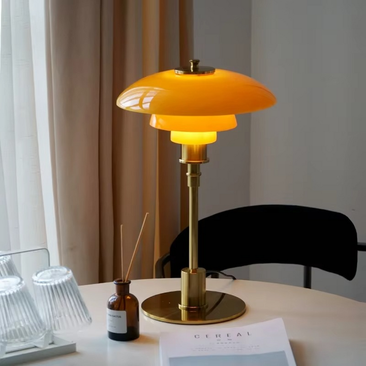 Contemporary Danish designer table lamp with warm LED light, sleek Scandinavian form, amber finish, and premium glass.
