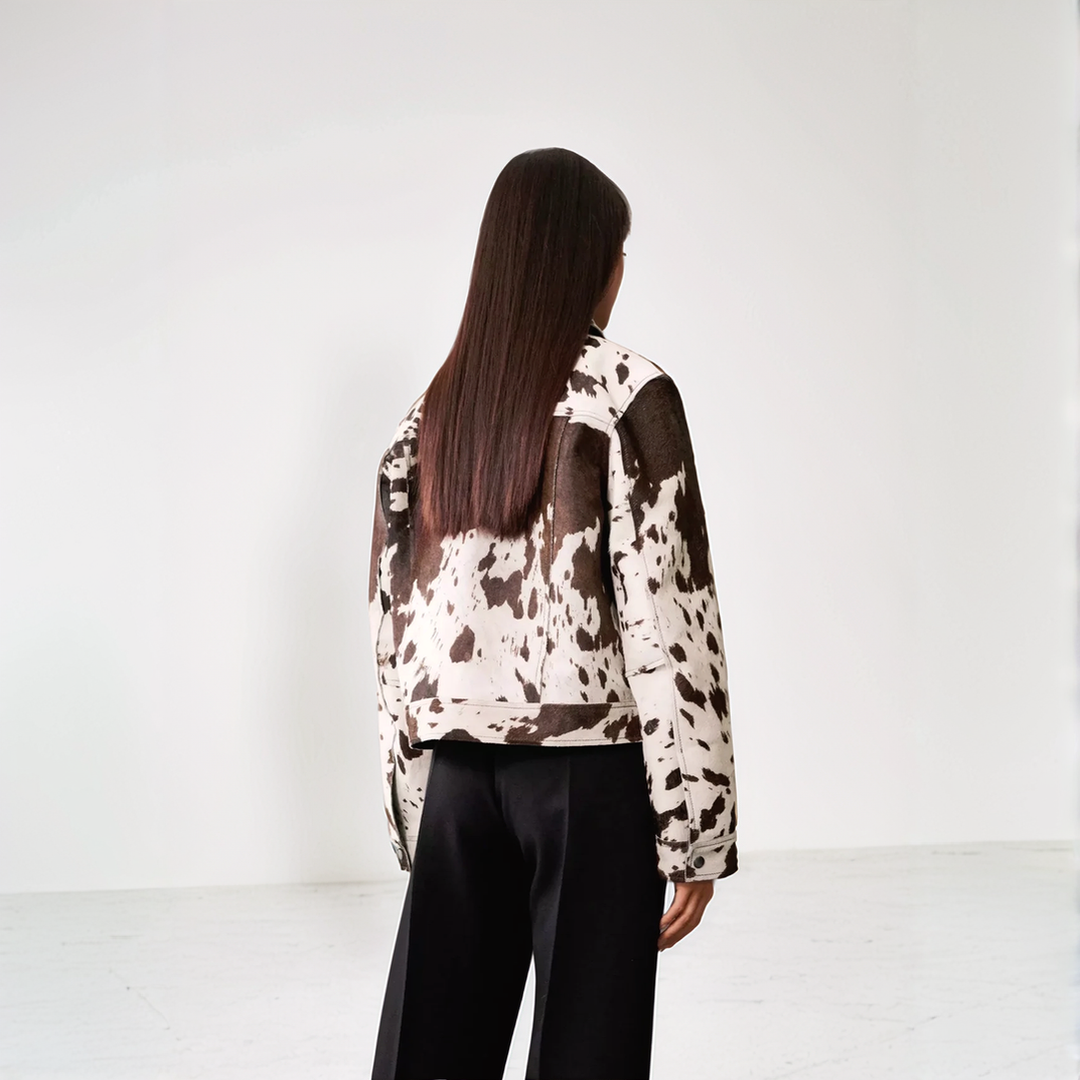 Cow print structured jacket, front view, single-breasted design, black and white pattern, women's fashion statement piece.