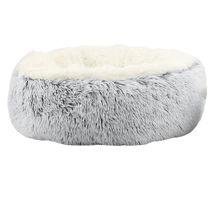 "Cozy plush donut dog bed with deep sides, faux fur, circular shape for comfort and anxiety relief in various sizes."