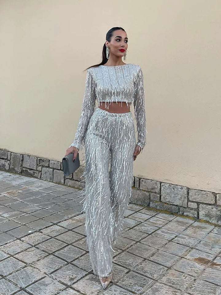 Shimmering women's sequin two-piece set. Elegant crop top & high-waisted fringe skirt, ideal for evening wear.