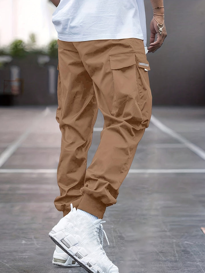 "Durable men's black cargo pants front view with multiple pockets, sleek modern fit, versatile style for urban adventures."