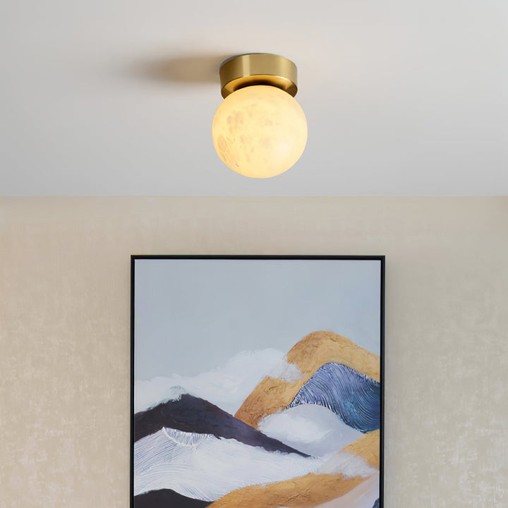 Elegant alabaster brass ceiling lamp, warm ambient light, celestial glow, sophisticated brass detailing, modern design.