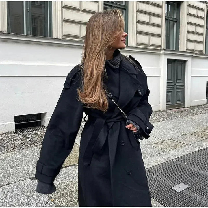 Stylish women's black long coat with double-breasted design, a versatile and elegant outerwear piece.