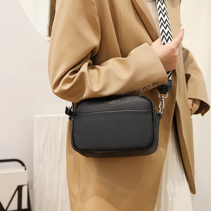 Elegant black leather crossbody bag for women, featuring an adjustable strap and stylish pebbled texture.