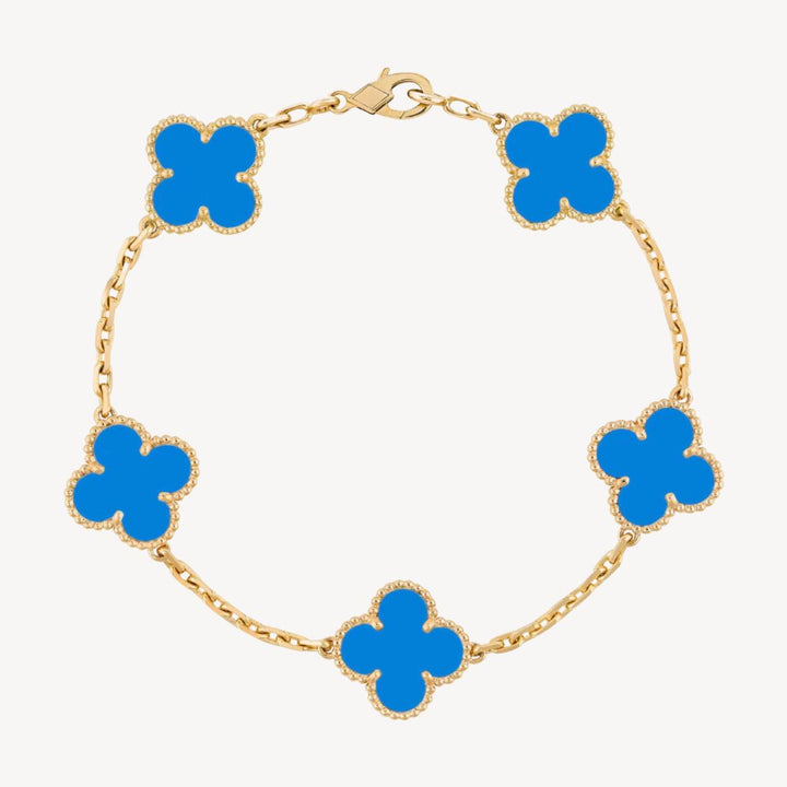 Elegant clover charm bracelet with polished black agate inlays and a gold and silver-tone chain for sophisticated style.