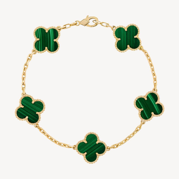 Elegant clover charm bracelet with polished black agate inlays and a gold and silver-tone chain for sophisticated style.