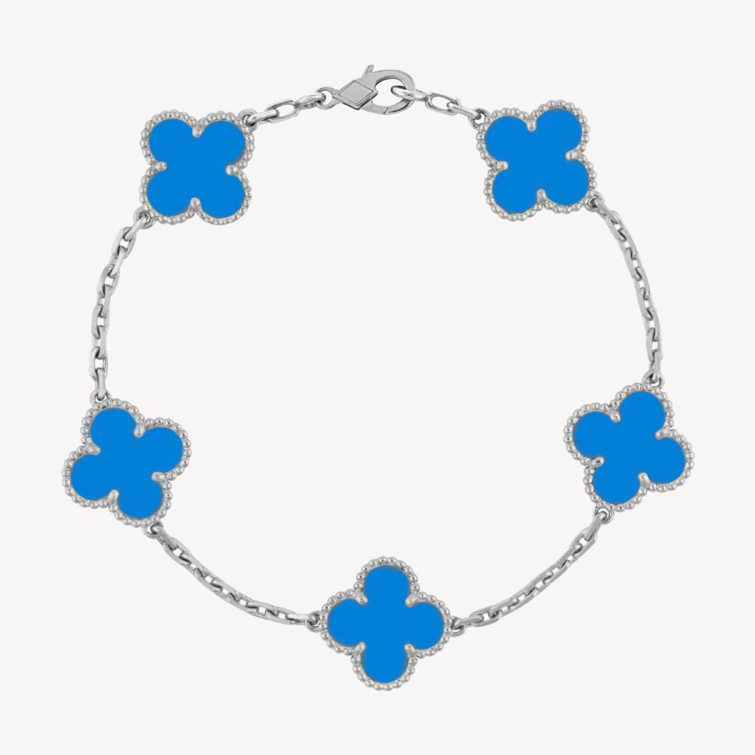 Elegant clover charm bracelet with polished black agate inlays and a gold and silver-tone chain for sophisticated style.
