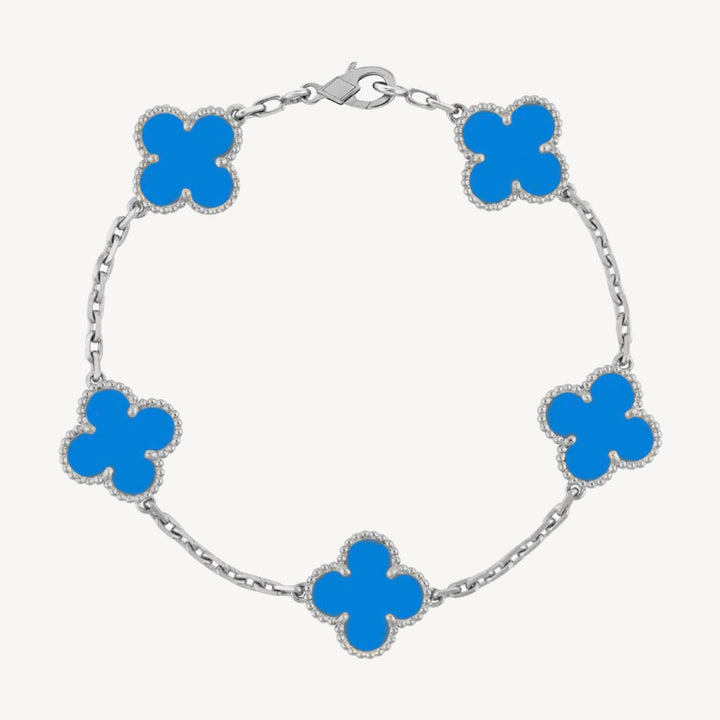 Elegant clover charm bracelet with polished black agate inlays and a gold and silver-tone chain for sophisticated style.