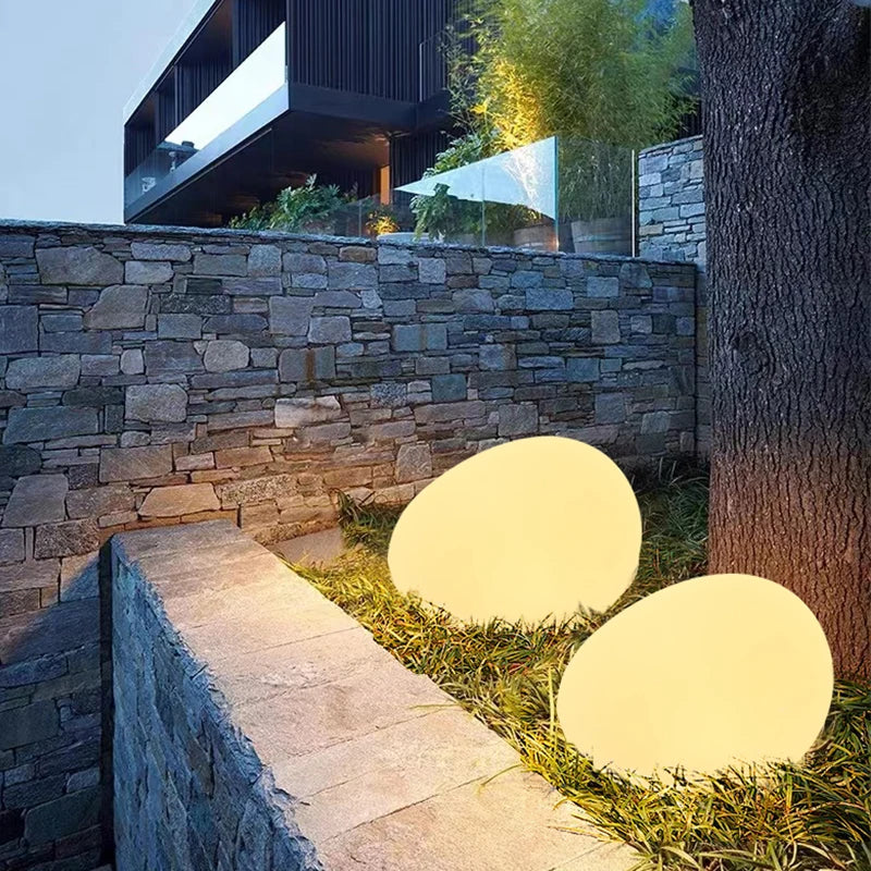 Elegant LED garden light with cobblestone design, glowing in multiple colors, ideal for illuminating outdoor spaces like gard