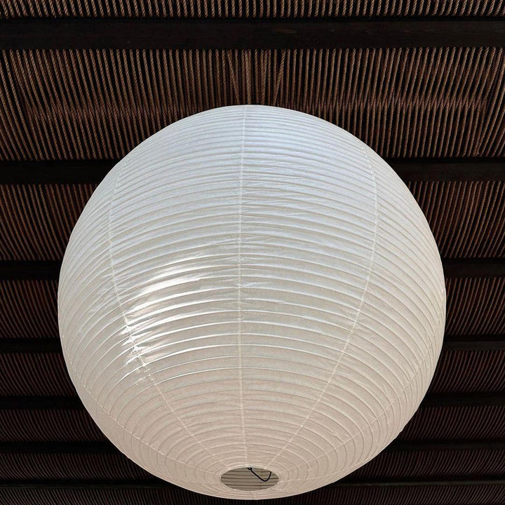 "Elegant modern Japanese paper lantern pendant light with a warm glow, blending contemporary and mid-century design."