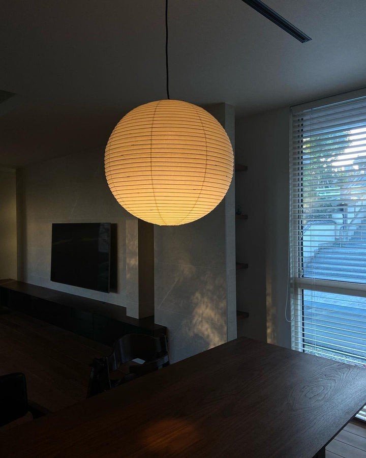 "Elegant modern Japanese paper lantern pendant light with a warm glow, blending contemporary and mid-century design."