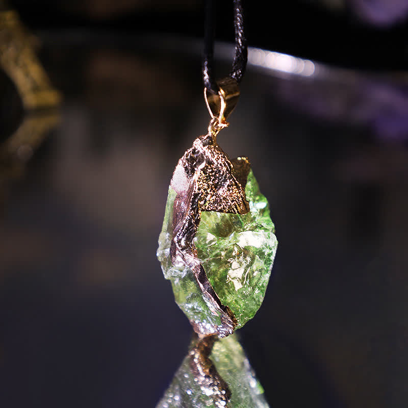 Elegant Moldavite necklace with unique design, featuring a green gemstone. Perfect for adding sophistication to any outfit.