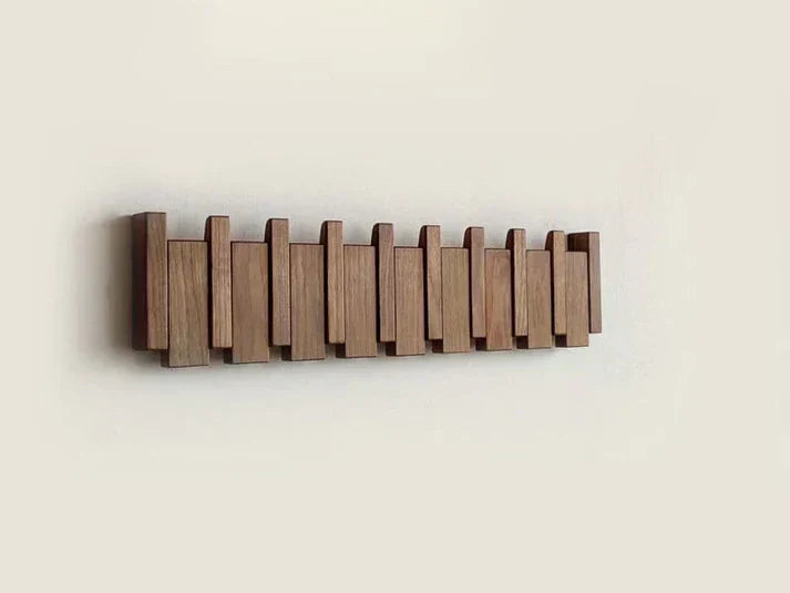 Beautiful wall-mounted piano coat rack in wood. Chic decorative hanger and storage solution for any modern entryway.
