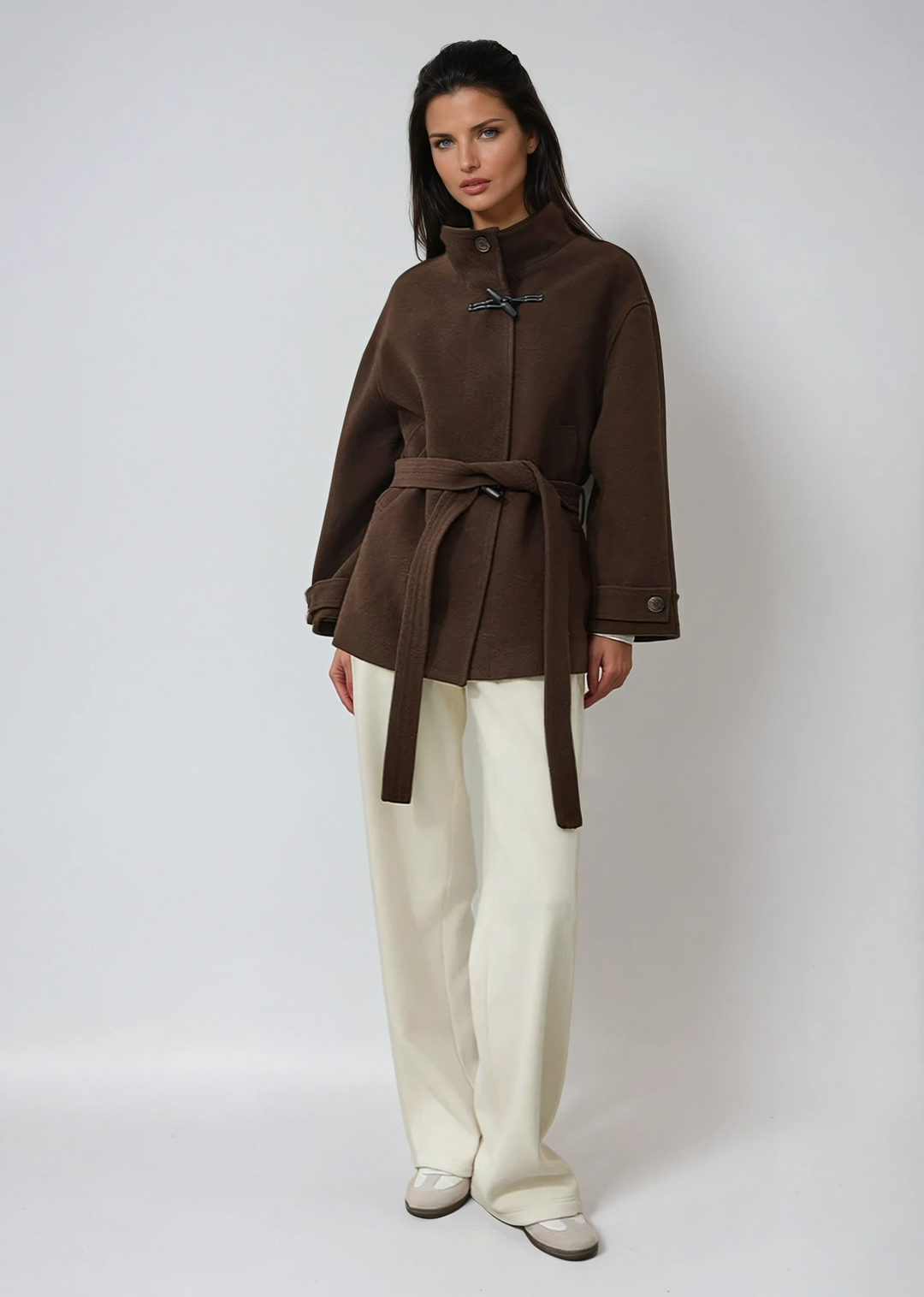 Elegant women's brown toggle coat with a flattering belted waist. Classic winter outerwear for cold weather fashion.
