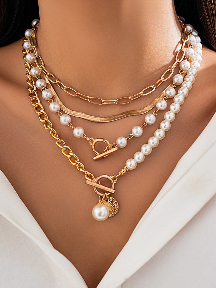 Elegant women's gold layered chain necklace with lustrous pearls. A perfect fashion accessory.