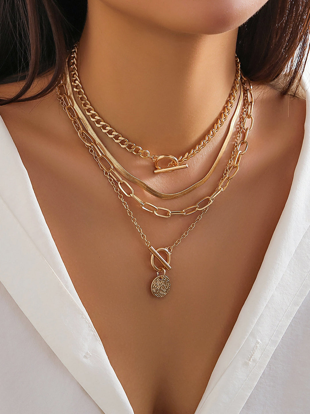 Fashionable gold layered necklace set for women, featuring multiple chains and elegant pendant designs. Women's jewelry.