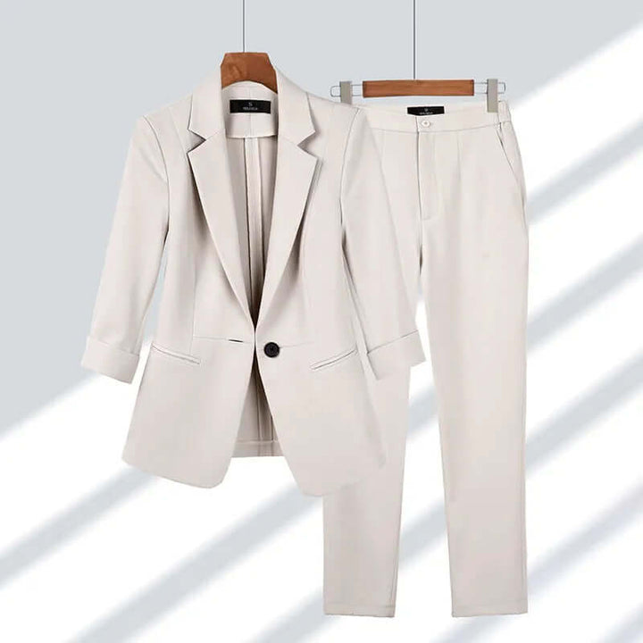 Elegant women's tailored suit set in black, featuring a fitted blazer and straight-leg pants for professional office wear.