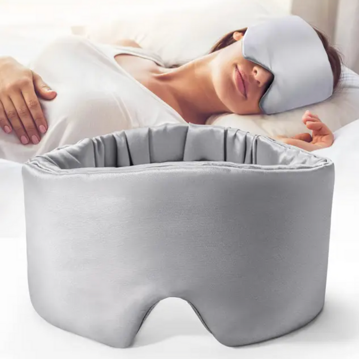 Luxurious unisex silk sleep mask, blocks 100% light; shown in elegant black with adjustable strap for comfortable wear.