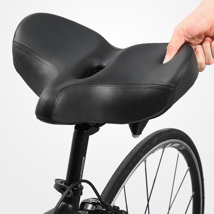 "Men's bike saddle with wide seat, ergonomic design, memory foam padding, black synthetic leather, and universal fit compatib