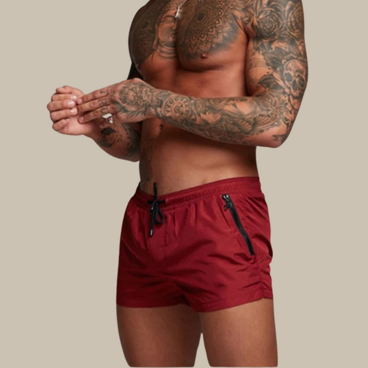 "Men's quick-dry, stretchy swim shorts with pockets in vibrant colors, featuring an elastic waistband and sleek design."