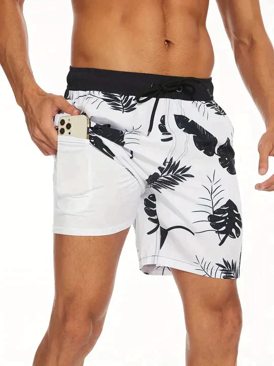 "Men's quick-dry swim shorts with inner compression, bold tropical print, two-tone detail, drawstring waist for secure fit."