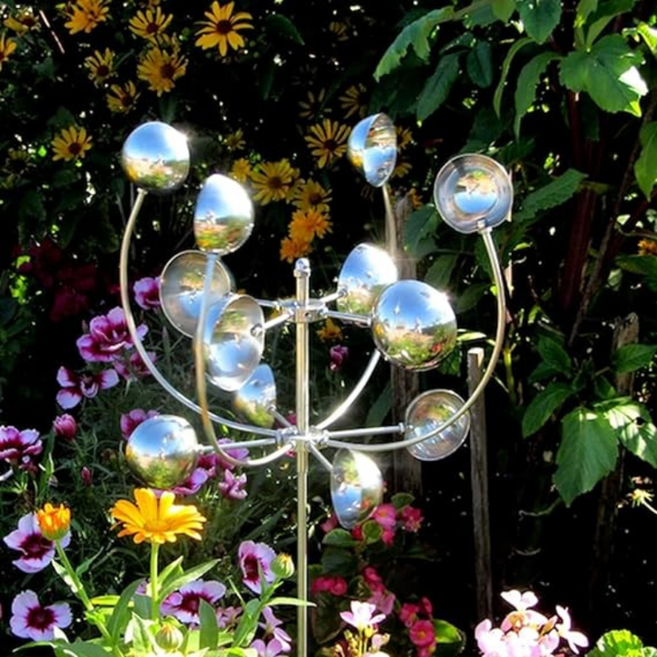 "Metallic wind spinner sculpture for garden decor, tall iron structure with dazzling finish, spins in the slightest breeze."