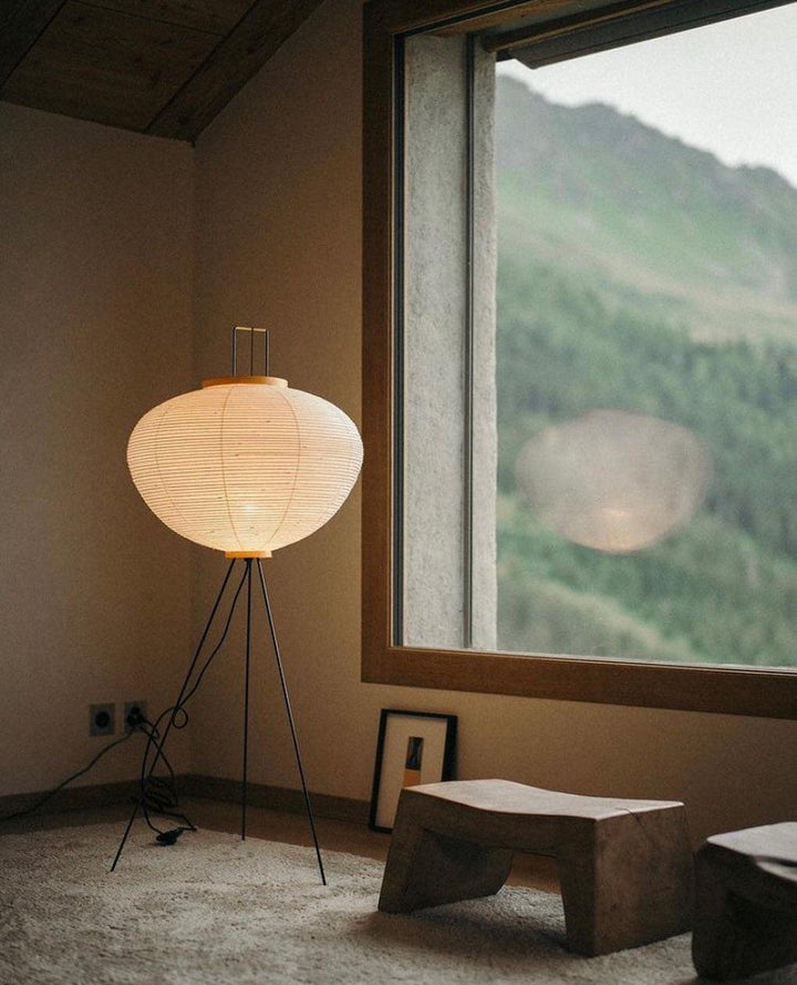 "Minimalist rice paper floor lamp with sleek metal frame and soft diffused light, perfect for creating a warm ambiance."