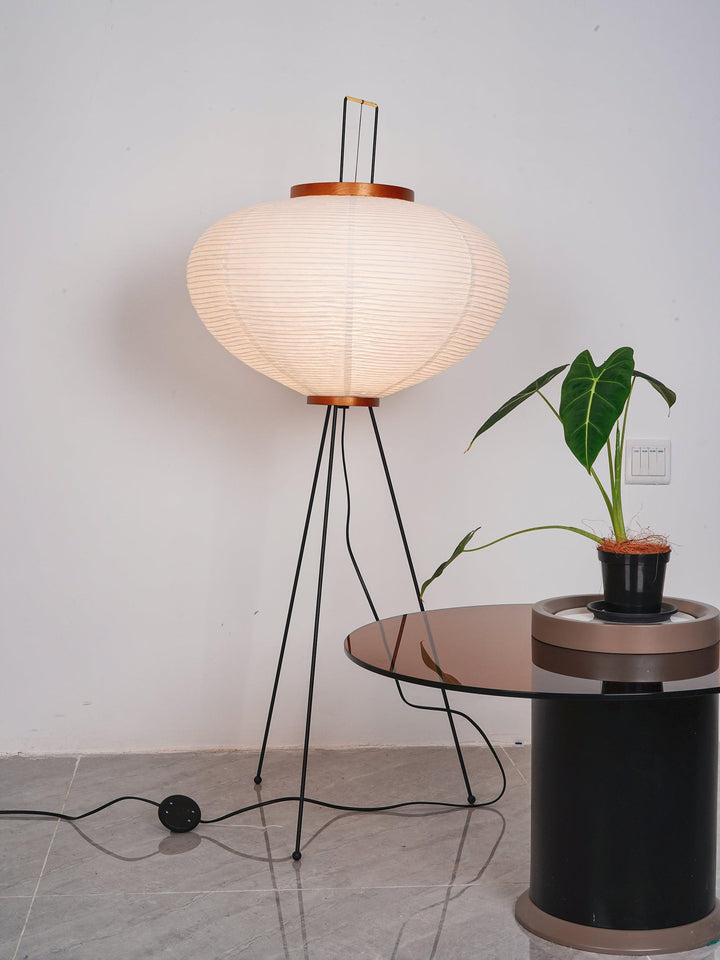 "Minimalist rice paper floor lamp with sleek metal frame and soft diffused light, perfect for creating a warm ambiance."