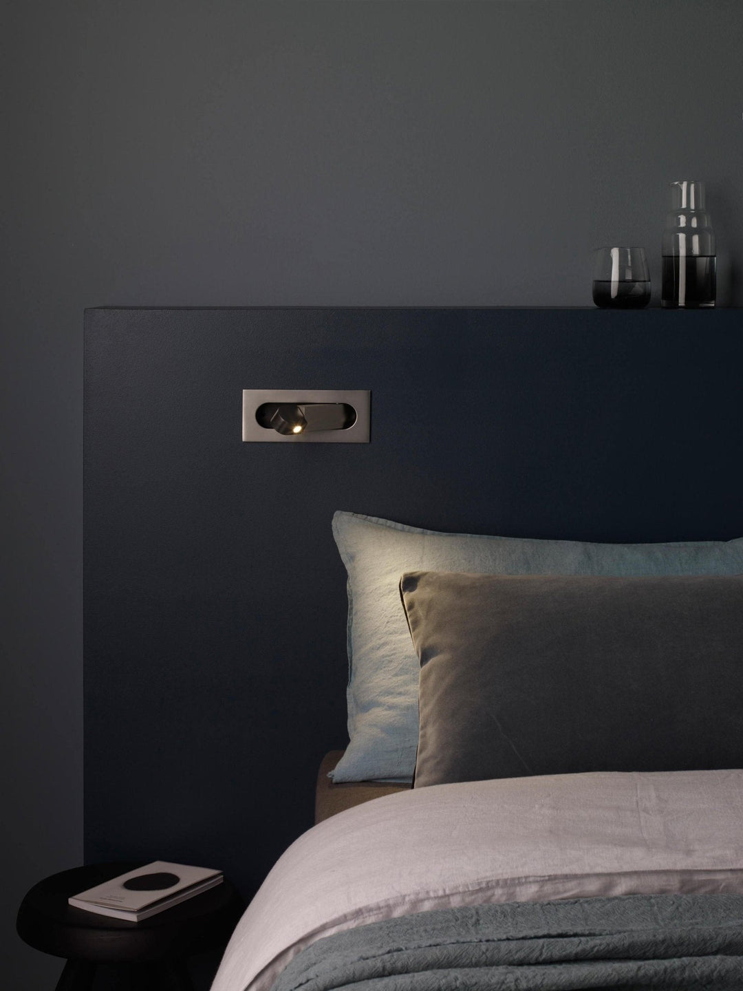 Modern adjustable LED bedside lamp in matte black with a sleek design, featuring an adjustable head for focused reading light