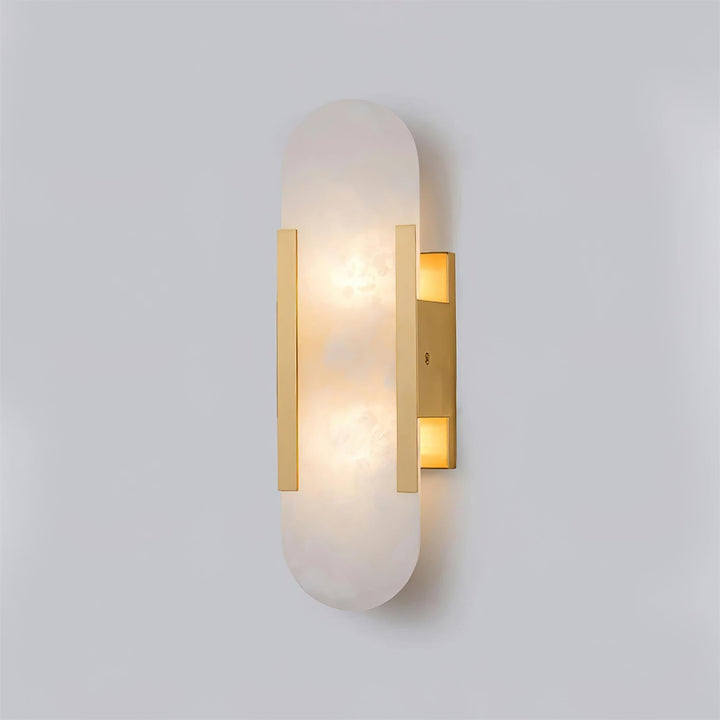 "Modern elongated alabaster wall lamp with metal and brass accents, emits warm glow, suitable for chic interior decor."