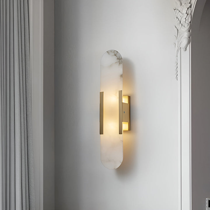"Modern elongated alabaster wall lamp with metal and brass accents, emits warm glow, suitable for chic interior decor."