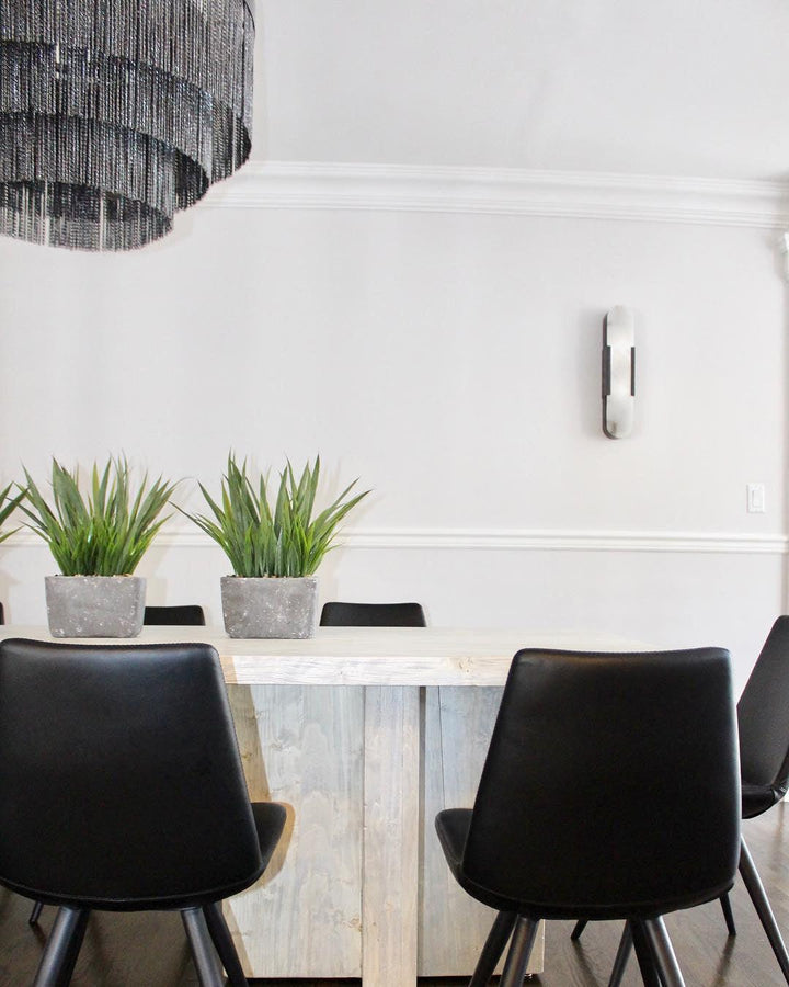 "Modern elongated alabaster wall lamp with metal and brass accents, emits warm glow, suitable for chic interior decor."