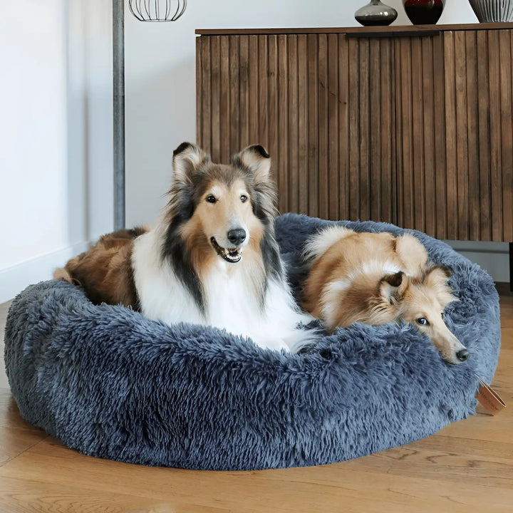"Plush luxury dog bed for anxiety relief in apricot color, round with raised rim, available in multiple sizes."