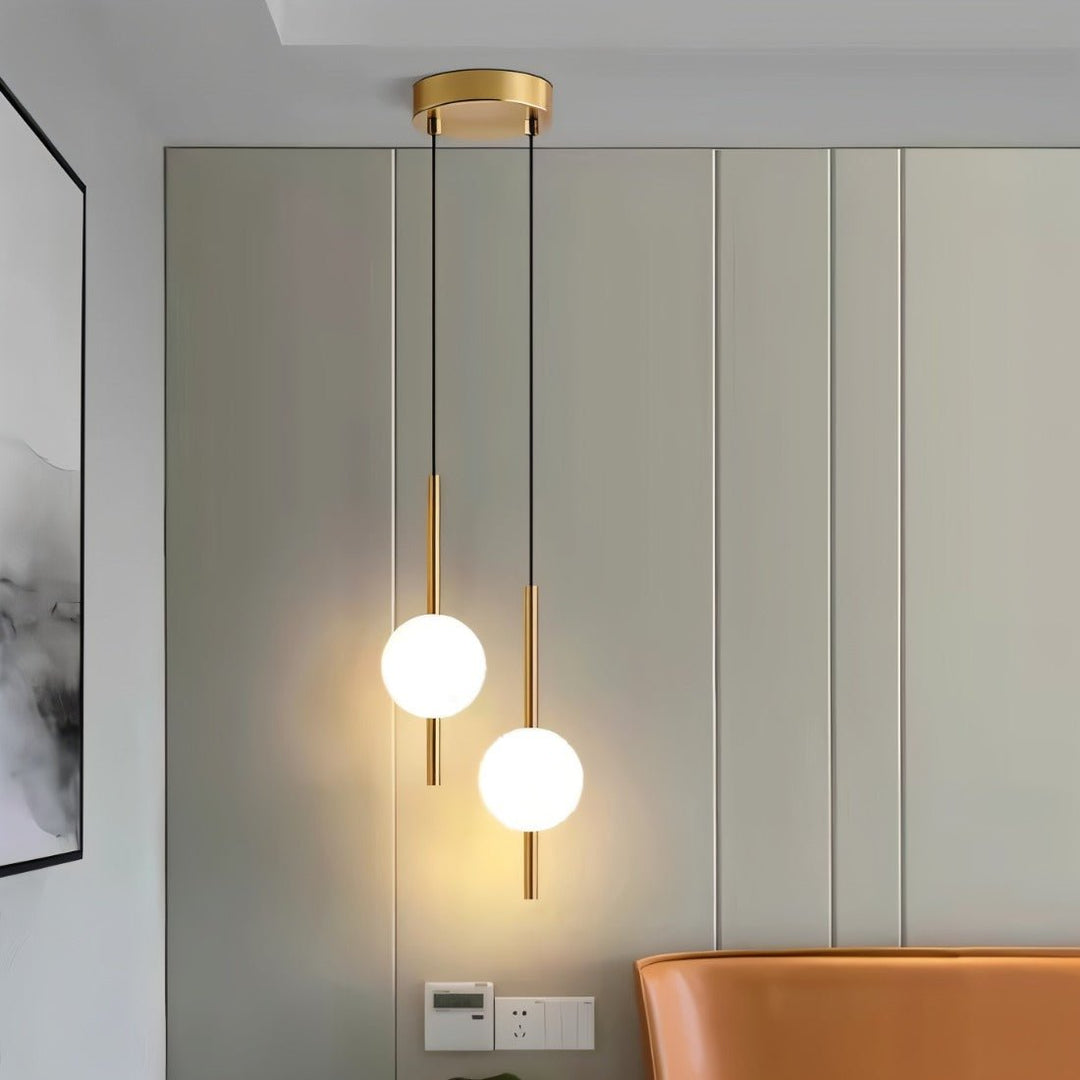 "Sleek glass ball Nordic pendant light with metal frame, LED bulb; available in black or brass, perfect for modern decor."