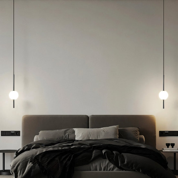 "Sleek glass ball Nordic pendant light with metal frame, LED bulb; available in black or brass, perfect for modern decor."
