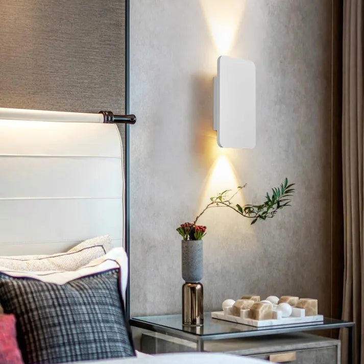 "Sleek indoor LED wall lamp with a modern rectangular design, featuring smooth finishes and warm illumination for elegant dec