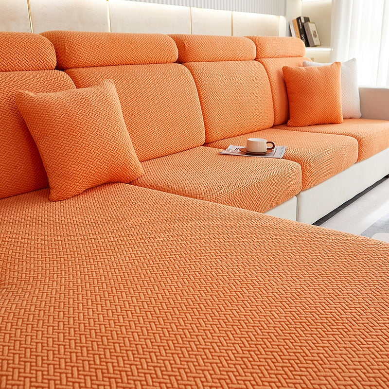 Stretchable sectional sofa cover in vibrant tangerine, snug fit, durable fabric, ideal for home decor and furniture protectio
