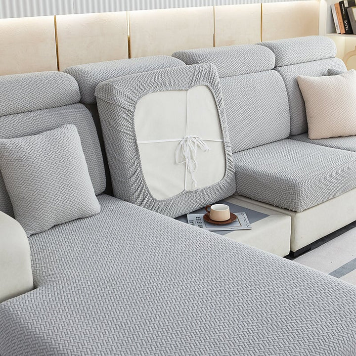 Stretchable sectional sofa cover in vibrant tangerine, snug fit, durable fabric, ideal for home decor and furniture protectio