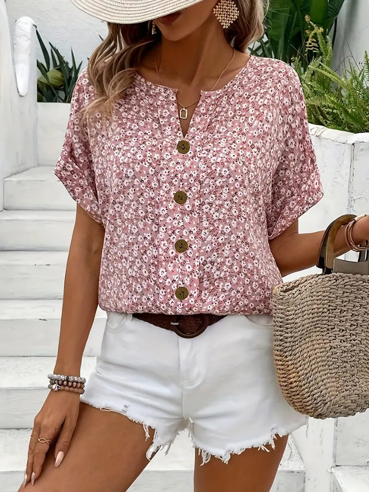 Stylish women's pink floral button-front blouse with short sleeves, perfect for casual summer fashion or spring outfits.
