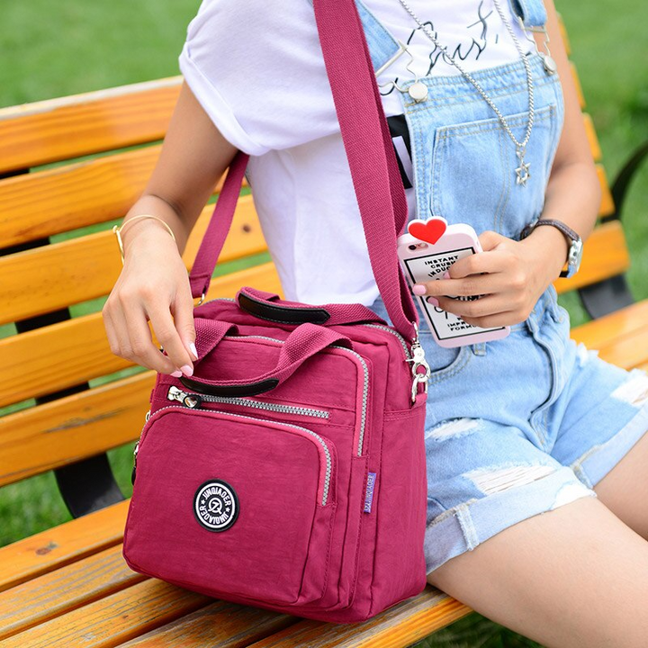Stylish women's water-resistant crossbody bag with adjustable strap, multi-pocket design, perfect for daily use.