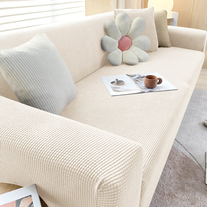 "Textured stretch sofa cover in beige, snug fit for sofas, non-slip, adds elegance, protects against spills and wear."
