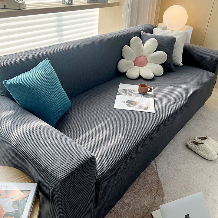 "Textured stretch sofa cover in beige, snug fit for sofas, non-slip, adds elegance, protects against spills and wear."