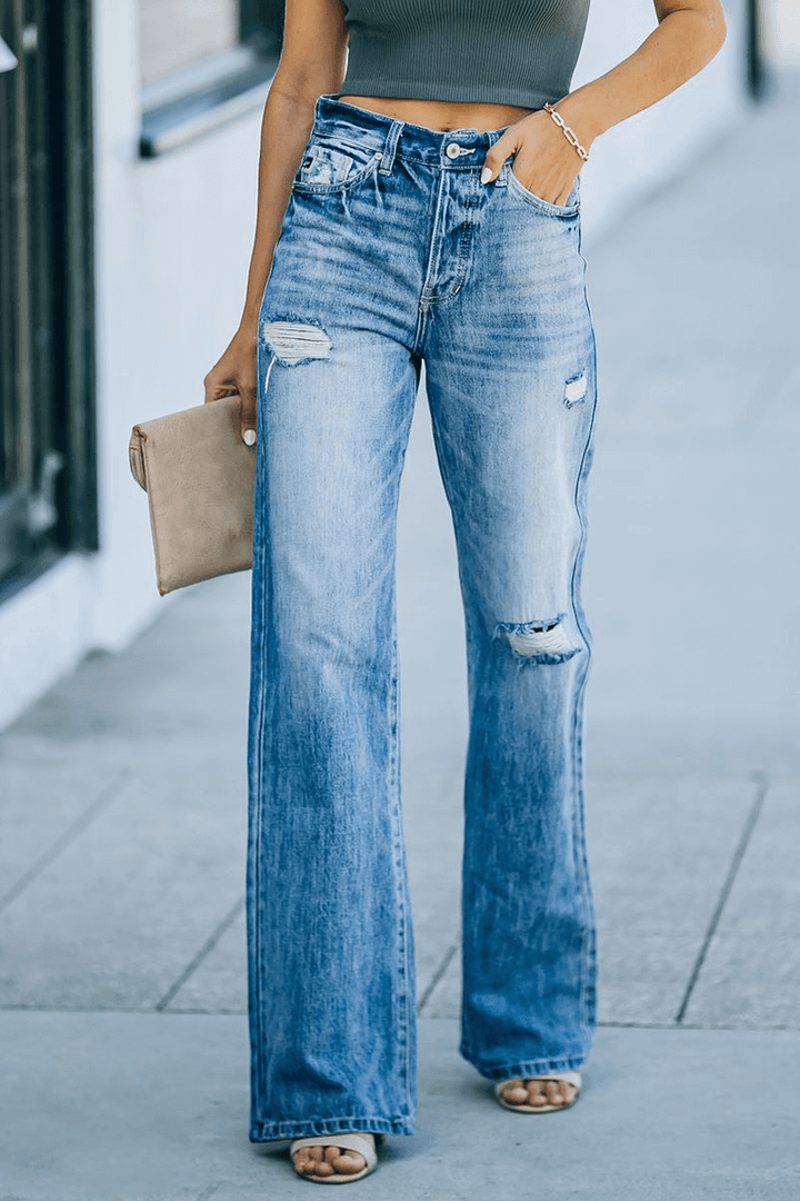 Trendy women's blue wide leg denim pants featuring stylish ripped details & playful tassels for casual wear.
