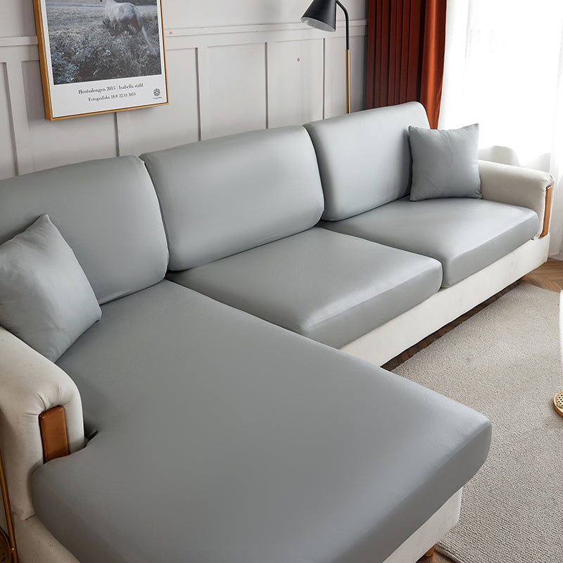 "Waterproof sectional sofa cover in smoke grey, sleek design for leather protection, durable stretchable fabric, snug fit."