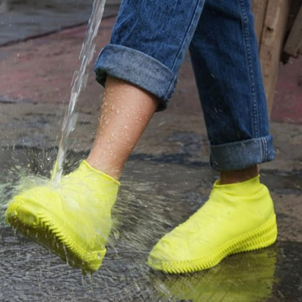 "Waterproof silicone shoe covers, anti-slip, foldable, unisex, shown covering shoes, durable and portable for any weather."
