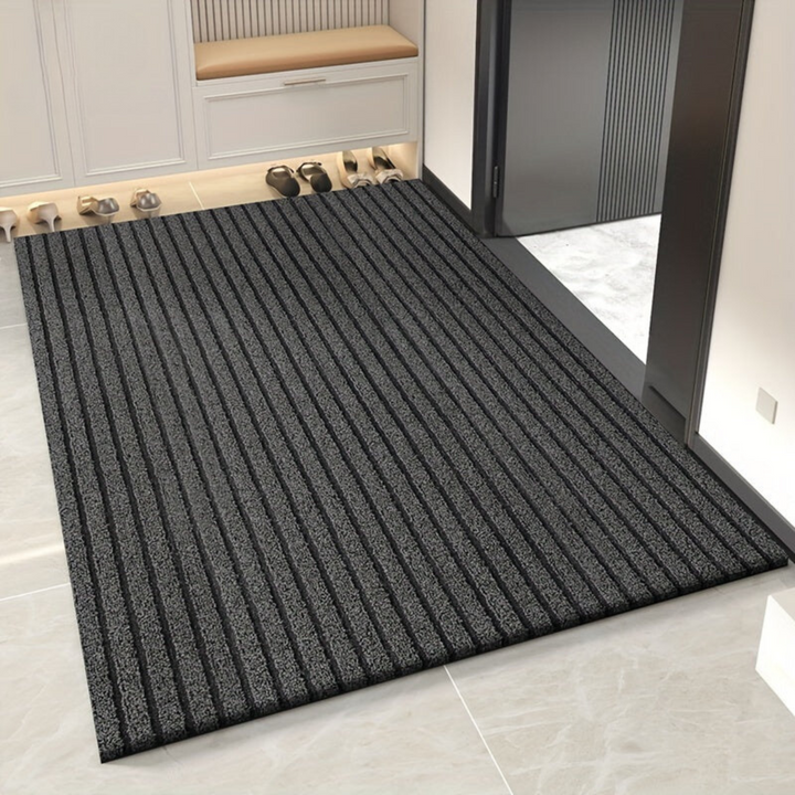 "Weatherproof non-slip outdoor rug with black and grey stripes, ideal for entrances and hallways, enhances safety and style."