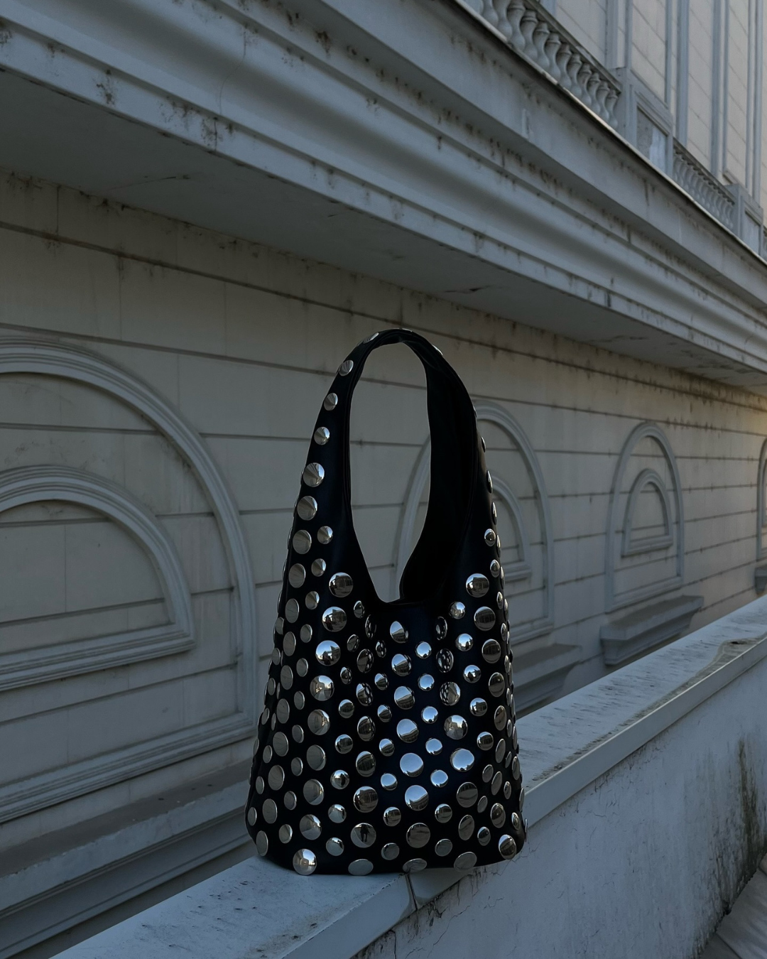 Elegant black women's handbag, a shoulder bag featuring trendy studded rivet embellishments.