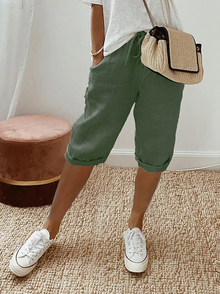 Stylish women's knee-length capri pants from the side, elastic waist & drawstring for versatile, comfy everyday wear.