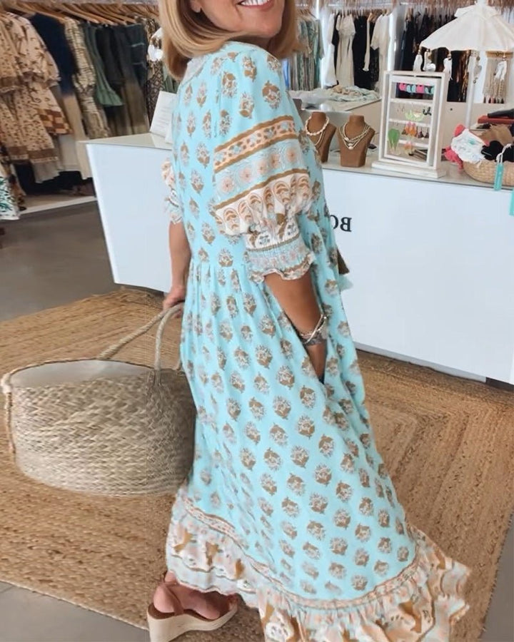 Flowy women's floral V-neck maxi dress swaying, ideal for a graceful summer look.