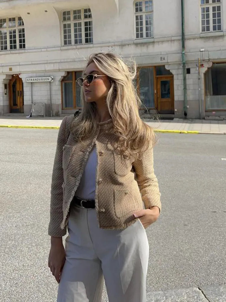 Elegant women's beige jacket with gold buttons, embodying timeless chic and versatile fashion appeal.